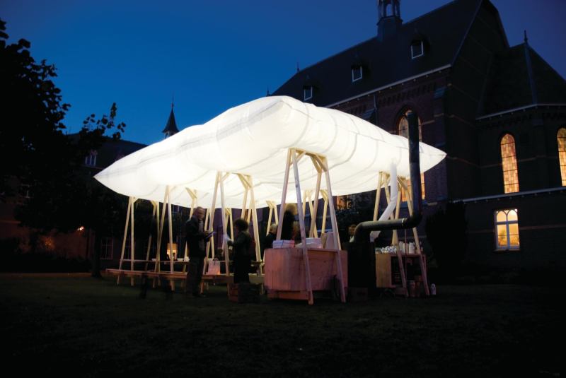 The Roof That Goes Up In Smoke is an inflatable pillowdesigned by Dutch spatial design studio Overtreders Wthat serves as the roof for a temporary pavilion. Inflated by hot air from a wood stove, the roof is lit at night to provide illumination for the space beneath it. The wood stove also doubles as the centerpiece of the mobile pavilion, which can accommodate up to 40 people. ¢ overtreders-w.nl