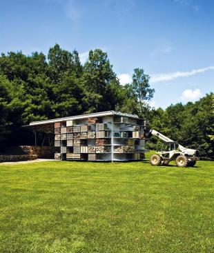 Pallets of landscaping materials create a mosaic of natural textures on the side of a storage barn in western Connecticut, enhancing the design of the compact structure while cleaning up the previously littered site.
