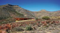 The planned Karoo Wilderness Center is a natural resource conservation-and-management center in the Karoo region of South Africa. Concrete walls and gum-pole-clad cupped roofs shelter conference areas, residences, lounges, and a theater, among other spaces.