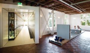 The exhibition galleries of the National Glass Museum occupy two historic houses on the Royal Leerdam glass factory site. Now opened to the public, these spaces hold rotating shows of glassware from around the Netherlands. The bulk of the company's archive and permanent collection is now stored?and on display?in a series of bridges that span the gap between the two houses.
