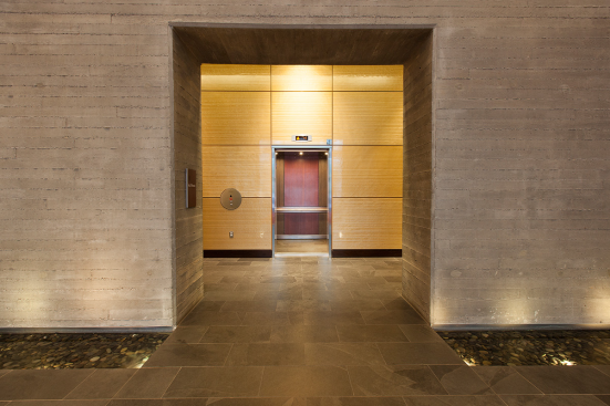 LEVELe-105 Elevator Interior with main panels in Bonded Bronze with Dark Patina and Rain pattern; accent panels in custom wood veneer at The Wyatt, Portland, Oregon