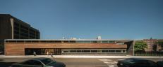 The main entry is located on the long face of the building, with its ipe cladding and slate tiles.