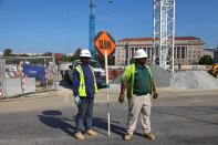 Construction workers direct traffic at the site.
