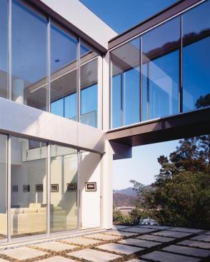 The exterior walls are made of limestone on the lower portion and are finished with smooth plaster on top. Limestone louvers create light shelves that let in winter sun. Inside, first-floor living spaces float free of the perimeter walls.