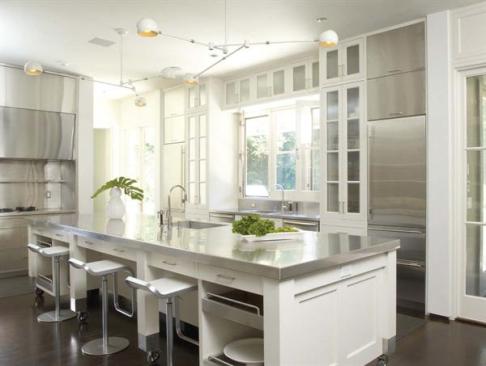 Striking contrasts ebonized floors and white cabinets, a mobile island and fixed appliances, contemporary stainless steel and traditional wood  punctuate the elegant room