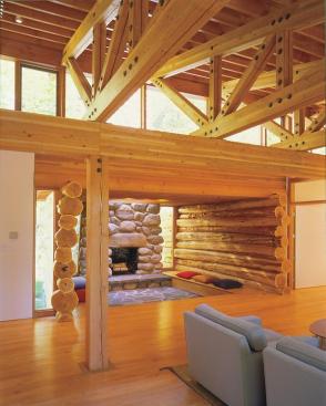 By sinking the fireplace nook a few feet below the rest of the main level and enclosing it with timbers and stone, the architects made it into an interior and exterior focal point.