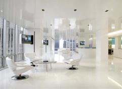 The apartment's white columns are more than just stylish structural elements. Some of them also contain retractable flat-screen televisions or conceal the HVAC system, with unobtrusive vertical slits serving as air vents.
