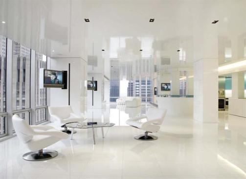 The apartment's white columns are more than just stylish structural elements. Some of them also contain retractable flat-screen televisions or conceal the HVAC system, with unobtrusive vertical slits serving as air vents.