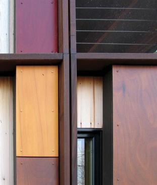 Alternating layers of glass, unfinished cedar, and glossy Prodema give the facade a dynamic quality.