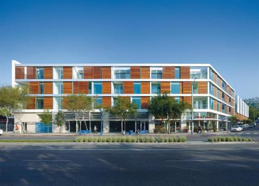 The project occupies a corner lot, with wood-screened flats and ground-floor retail on the Santa Monica Boulevard side.