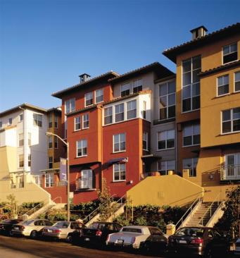 The town houses feature strong connections to the urban outdoors, too, via patios and bright, double-height living areas with windows at either end.