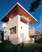 A large inverted roof is angled to provide shade for the homes many decks and porches during summer and admit sunlight in winter.