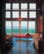 "This house is like a huge porch surrounded by grasses," architect Suman Sorg says. Doors and windows in the living room look west over the Chesapeake Bay.