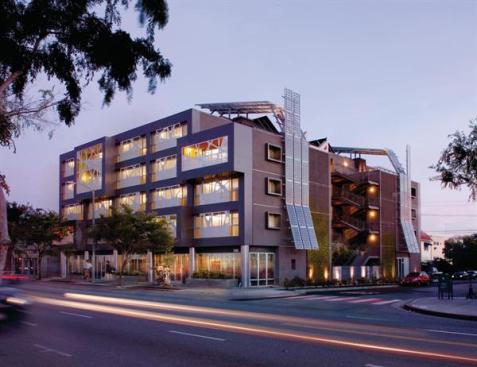 Rather than viewing photovoltaic panels as something to hide, architec Patrick Tighe transformed them into a key design element on the rooftop and side of the building.