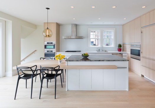 Modern upscale kitchen with light wood floor and cabinets