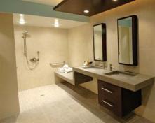 The shower's parallel "wet" and "dry" benches allow a caretaker to stay dry while helping the client's son bathe.