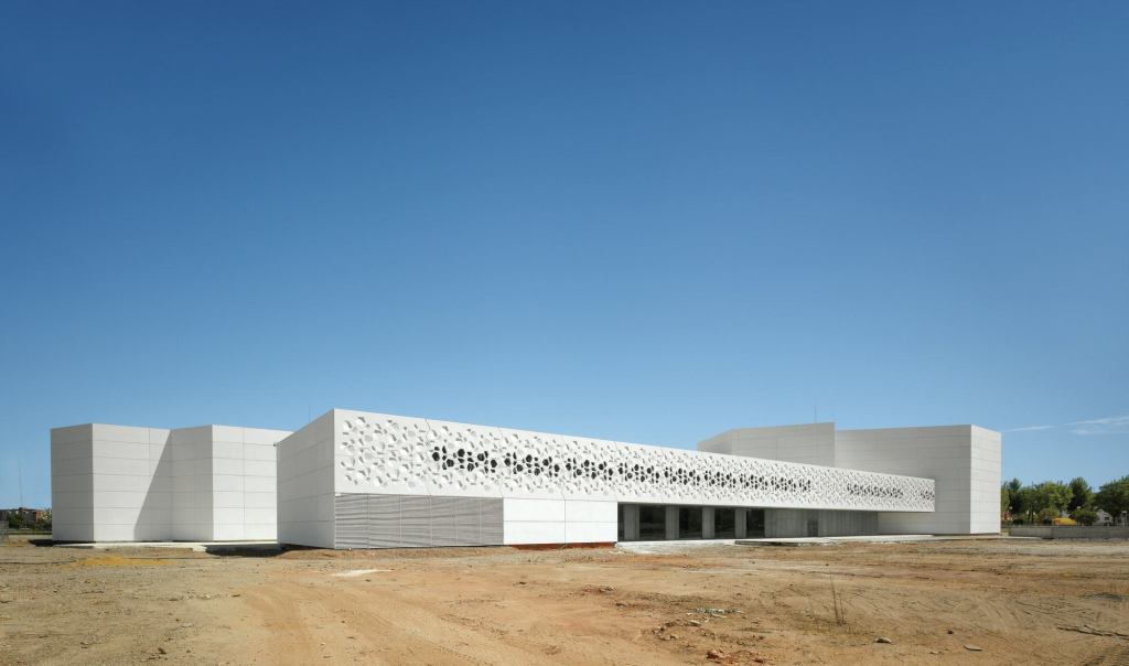 Polygonal perforations, abstracted from the building’s hexagon-based design, cascade across the exterior of the Contemporary Art Center in Córdoba, Spain, allowing natural light to dapple its interior.