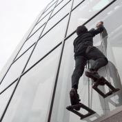 Elliot Hawkes, a mechanical engineering graduate student at Stanford University, scales the exterior of a glass wall using adhesive grips.