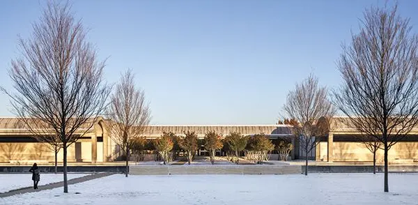 The main entrance, with its grove of trees. View from the west.