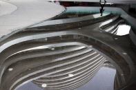 A man's reflection as he walks past the Galaxy Soho on May 15. Zaha Hadid, Hon. FAIA, designed the building in Beijing, China.