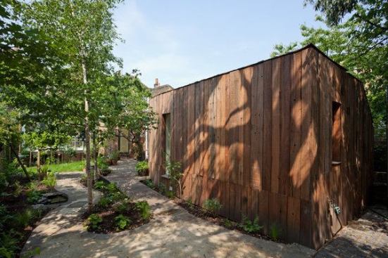 View from the southeast, showing the wood-clad volume that holds the bathroom and bedroom.