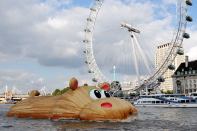 The 'HippopoThames' sculpture is towed past the London Eye. Florentijn Hofman, a Dutch artist known for his giant Rubber Duck project, designed the 69-foot-long hippo for the River Thames. The artwork was inspired by research from the National History Museum that found hippos once occupied the river.