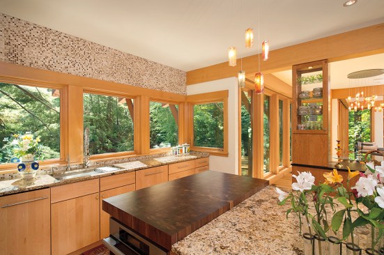 
  Nestled
  away adjacent to a lake, this lakeside residence is an example of fixed
  rusticity. The bright oak finish glows in comparison to the lush green forest
  beyond, creating a certain brightness throughout the home.