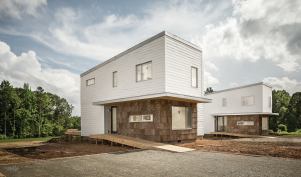 The neighboring prefab houses in South Boston, Va., look identical, but the left EcoMod prototype is built to Passive House standards, while the right unit is built to code only. John Quale and his team are monitoring their energy performance under occupancy.