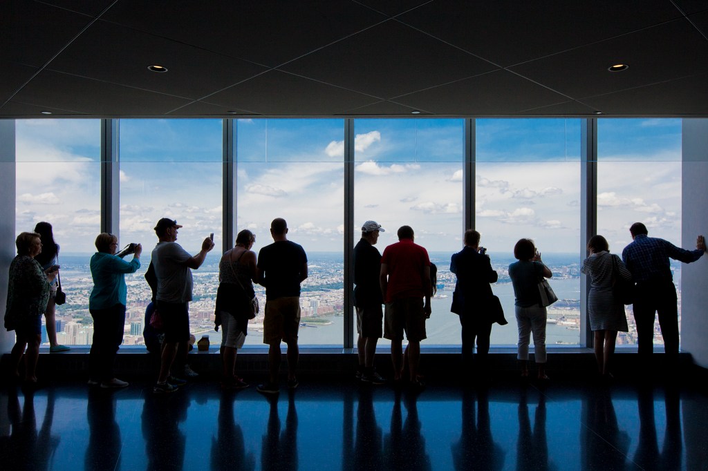 Tourists view New York from the One World Trade Center observation deck.