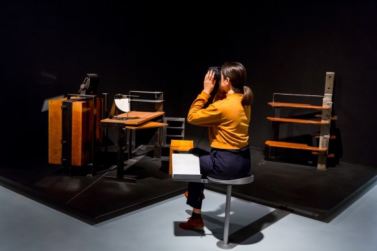 A visitor to the exhibition wears virtual reality goggles that offer a 3D experience of Chareau's furniture in its original context