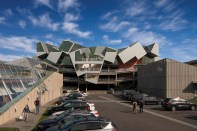 Pterodactyl's western facade overlooks a parking lot framed by four other Eric Owen Moss projects: The Umbrella (at right), Slash (at left) and Backslash, and Stealth. The new office and exterior stair projects out and over an existing parking garage.