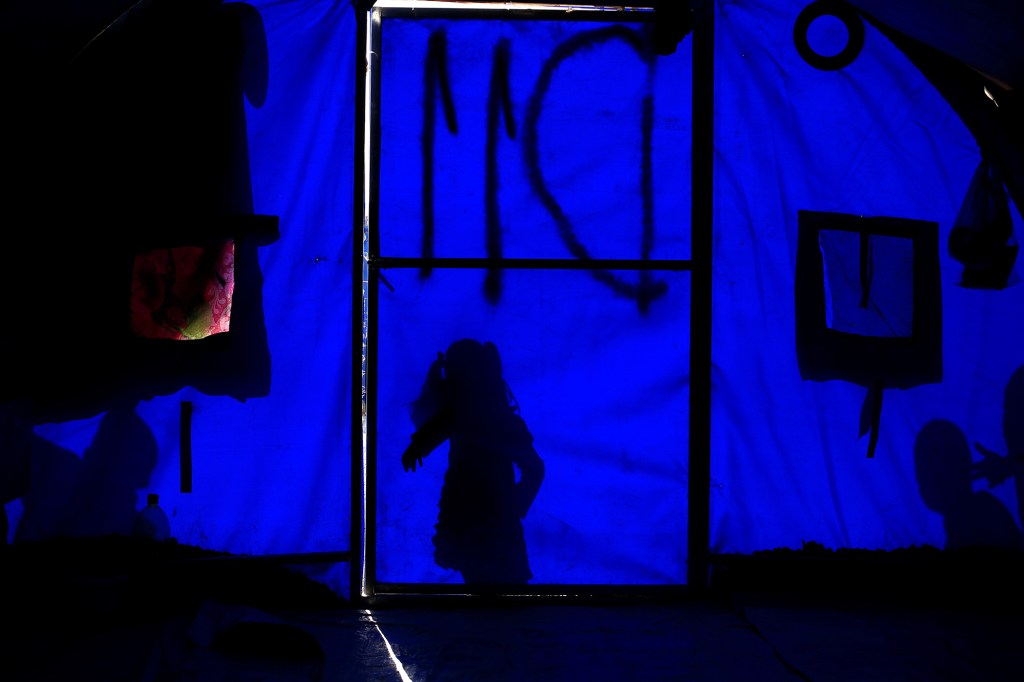 In November, a newly displaced girl stands outside a tent in the Khazer refugee camp in Iraq