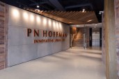 The multi-faceted lobby introduces the office’s design intent– reflect the area’s rich history, the beauty found in the simplicity of building, and PN Hoffman’s entrepreneurial journey from local developer to prestigious shaper of cityscapes. Wingate Hughes accomplishes this with elegantly executed elements like the sheeting and shoring-lined lobby, commonly used when installing the foundation of a building or on a vessel, and the custom angled, multi-ribbed wood-slat ceiling reminiscent of the underbelly of a ship.