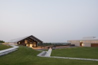 The event space (at left), which is used for everything from weddings to farmers markets, opens onto a central lawn. The green also covers a field of geothermal wells.