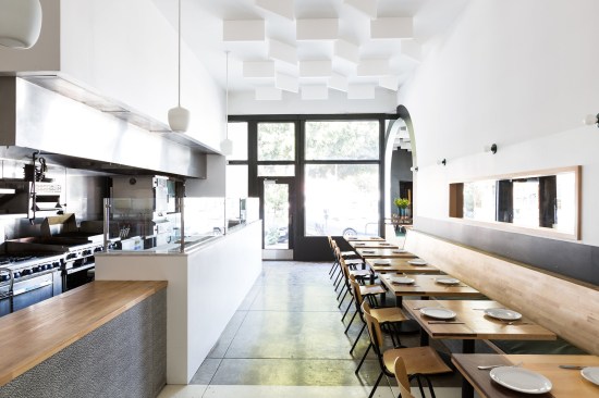 Repeating archways and sun motifs create continuity between juxtaposed dark and light seating areas of a Taiwanese soul food restaurant in the Mar Vista neighborhood of Los Angeles.  