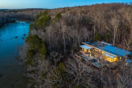 Perched on a knoll above the Haw River rapids in Chatham County, the 2600-square-foot house was designed to be perfectly at home within its wooded site overlooking Haw River.
