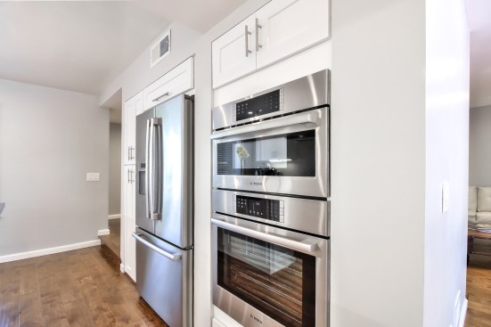 White shaker cabinet, Open space kitchen with quartz counter top. 
Wood flooring 