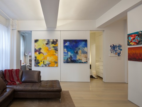 The bedroom is enclosed by large scale sliding panels which double as art walls. The walls may be closed while entertaining guests and opened to completely integrate the bedroom and living room into one open space.