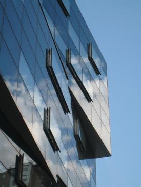 Street-level units are sheathed with translucent glass channels, and a glass sidewalk transmits natural light into the lower-level studio spaces while engaging passersby.
