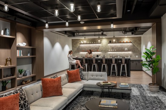 Ceiling features also help to define spaces, with metal grids and lighting fixtures suspended beneath the exposed ceiling.