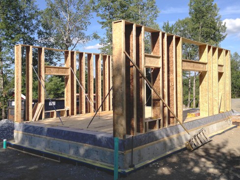 Figure 7. Passive House design often pairs 2x4 structural bearing walls with vertically applied wood I-joists for maximum cavity insulation. For this project, we wanted the wood I-joists to serve both our structural and insulation needs. And so, with our structural engineer’s blessing, we framed our high-performance “bearing” walls with 16-inch-deep wood I-joists—to our knowledge, this is the second home in the U.S. to so. Prior tilting up the walls, we folded the Mento membrane into place.