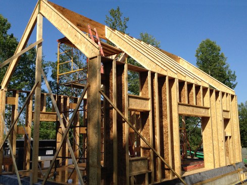 Figure 8. We framed the 10:12-pitched roof with 16-inch-deep wood I-joists, placing them in line with the wall framing. The resulting cathedral ceiling was later filled with dense-pack cellulose. For shear, we installed OSB gussets on the inside flanges of the I-joists (the exterior was sheathed with exterior gypsum board to help prevent racking). I-joists were installed above window and door openings to create open headers, which were easily dense-packed with cellulose.