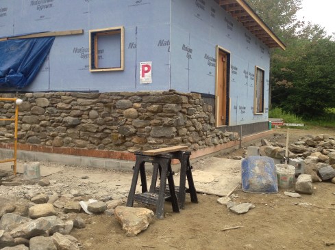 Figure 17. Two block courses brought the wall up to finish grade. Copper perimeter flashing was placed on top of the block with Cedar-Breather lapping its vertical leg. The fieldstone veneer was laid up with a roughly 2-inch air space between it and the Cedar-Breather and was tied back to the wall with masonry anchors fastened to the wood I-joists.