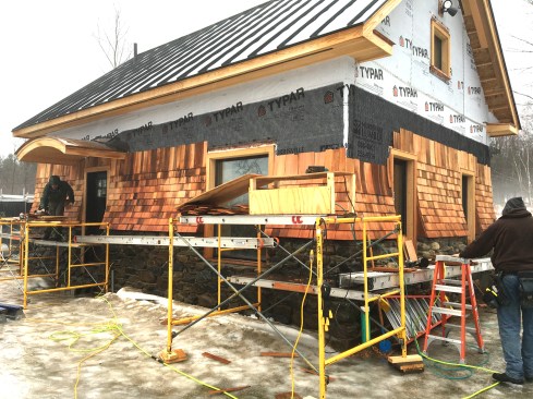 Figure 18. Originally, the home was to be clad entirely with fieldstone, but the stone proved difficult to work with and was taking too long to put up. We ended up shingling the upper portion of the wall, which in the long run, I believe, made for a better-looking home. We created a flared shingle detail, which made a nice, durable transition between the stone and shingles (see shingle flare detail).