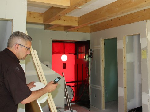 Figure 20. With the drywall installed, Jim Bradley, of Caleb Contracting, in Cambridge, Vt., performed the blower-door test in early June 2016 (Jim has to break out the blower door’s“D” ring—see video). The home averaged 76 cfm (65 cfm for depressurization and 87 cfm for depressurization), which translated to 0.45 air changes per hour at 50 Pascals—this is one really tight, high-performance country cottage.