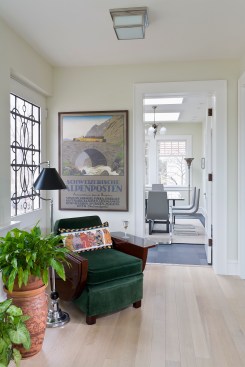 Vintage dark green velvet chair in sun room with view into dining room