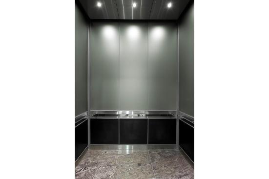 LEVELe-105 Elevator Interior with upper panels in ViviChrome Chromis glass with custom color interlayer and Opalex finish; lower panels in Fused Graphite with Sandstone finish; and Rectangular handrails in Polished Stainless Steel at Mission City Corporate Center, San Diego, California