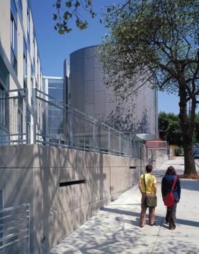 A zinc, ovoid-shaped lounge structure anchors the campus-facing side.