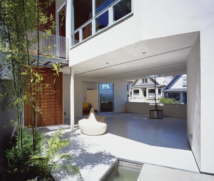A+sheltered+outdoor+space+tunnels+through+the+building%2c+joining+its+private+and+public+sides.