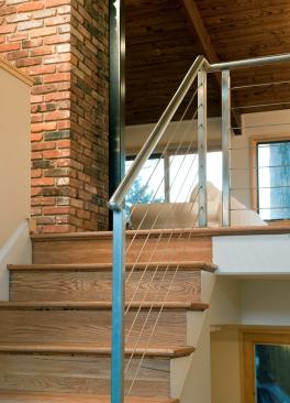 Inside the new foyer, old partitions and railings were replaced with new low walls and cable railing to expand the view upward and inward upon entering the home.